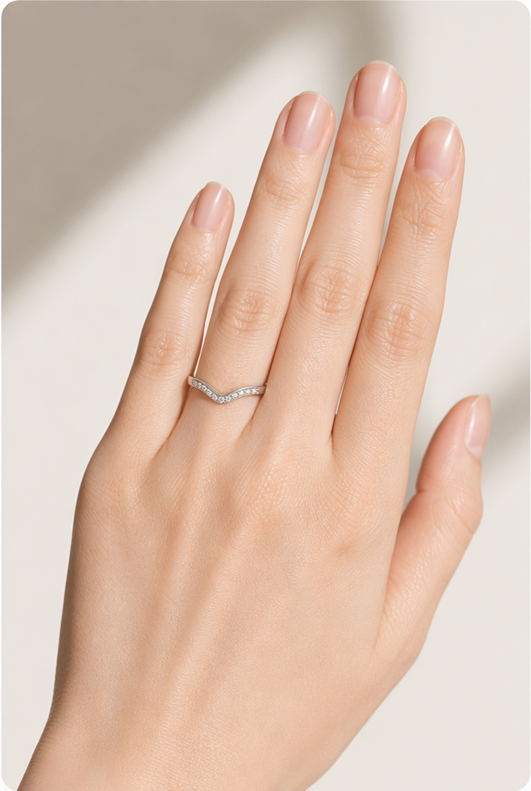 Engagement ring paired with a curved wedding band on the hand