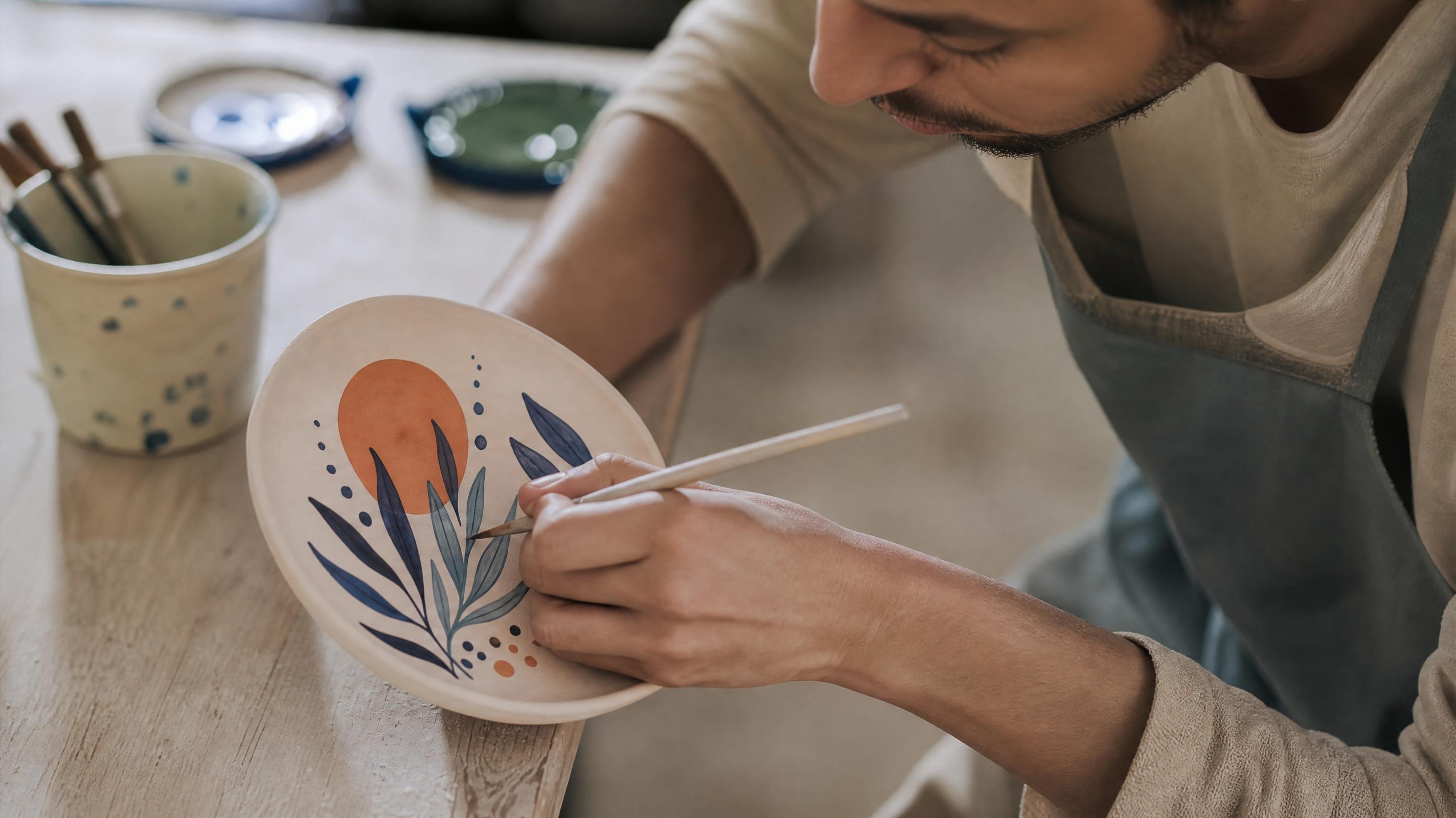 A man is making a hand-painted plate